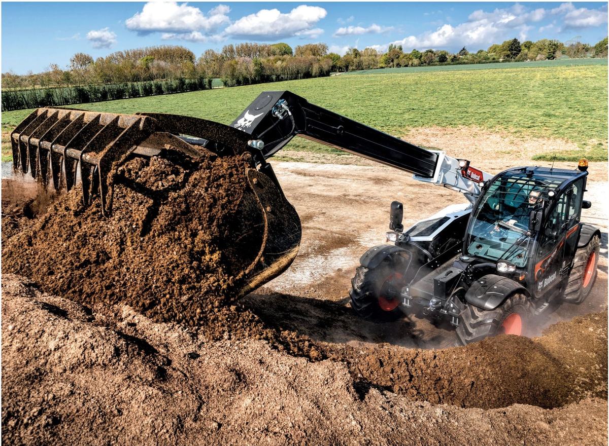 Bobcat telehandler with a rake bucket working on a farm